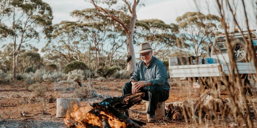 Max sitting at a campfire in the bush