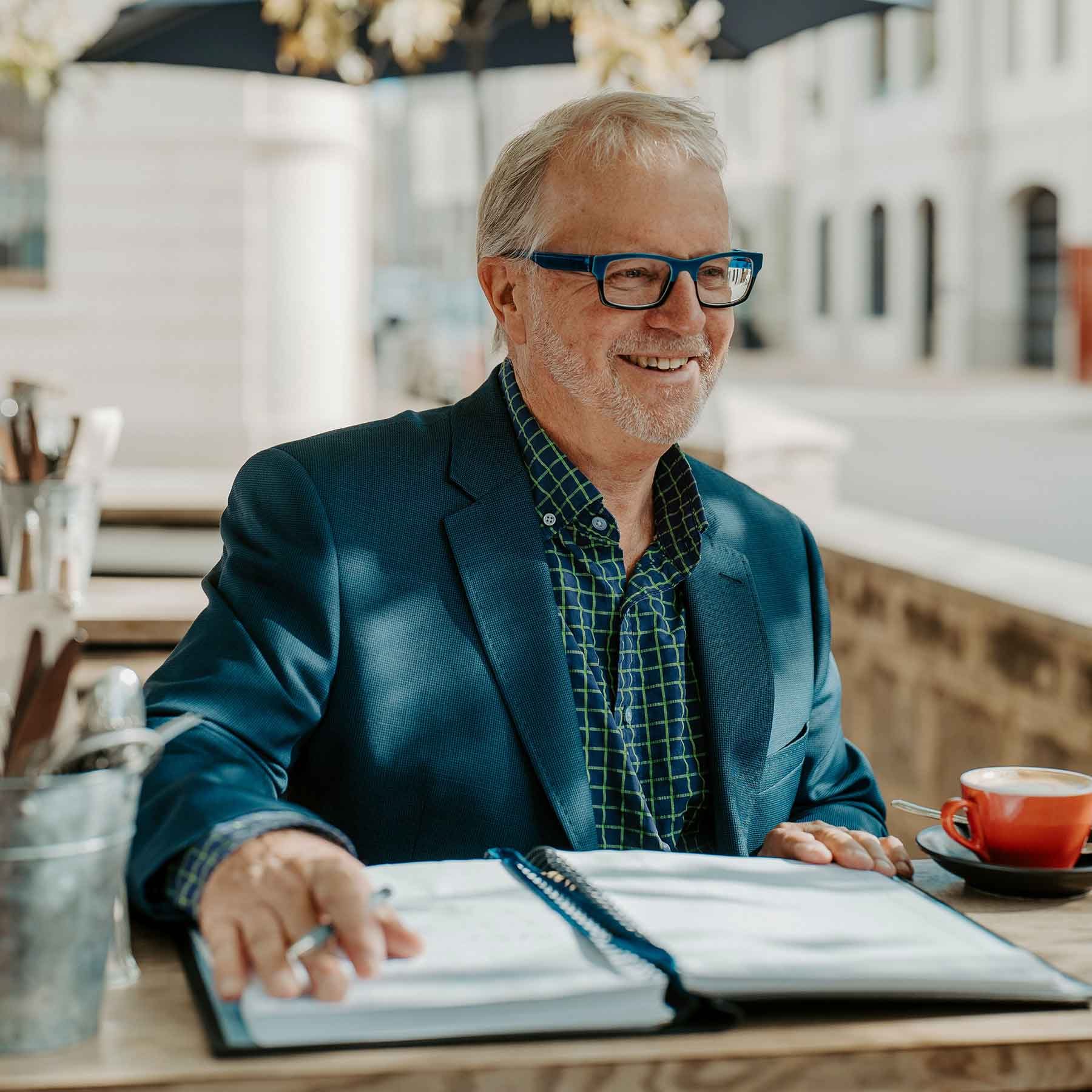 Max talks to a client in a Fremantle café